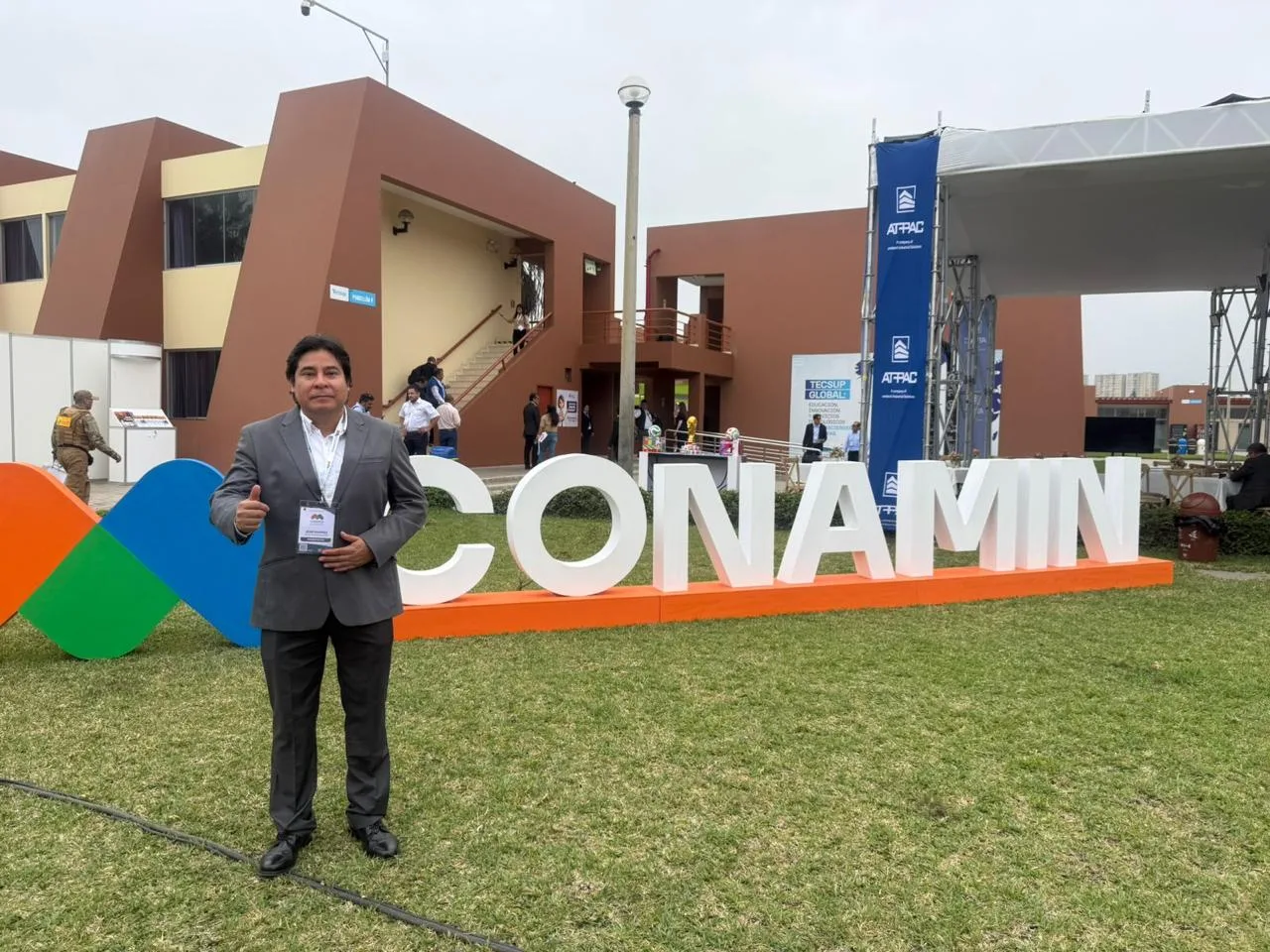 Ing. José Luis Ramírez Castañeda junto al letrero de CONAMIN en la sede del congreso